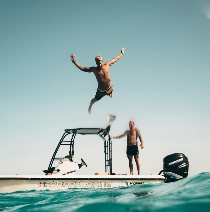 A man jumping off a boat into the ocean