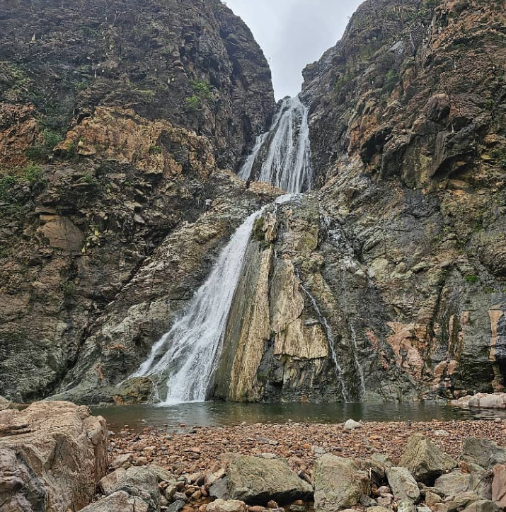 A large waterfall is in the middle of a rocky area in Socotra island 