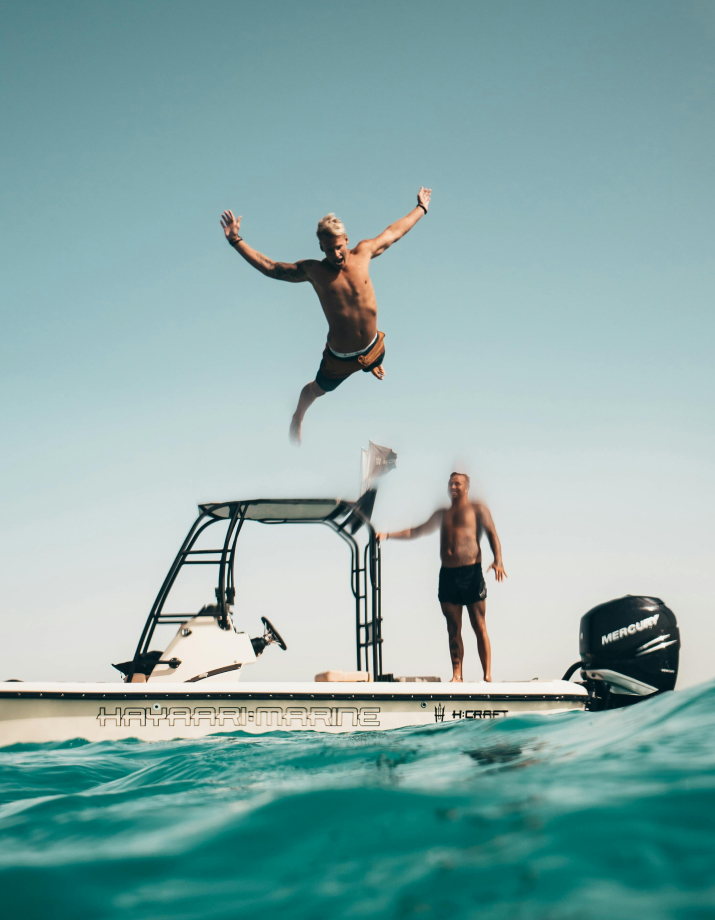 A man jumping off a boat into the ocean